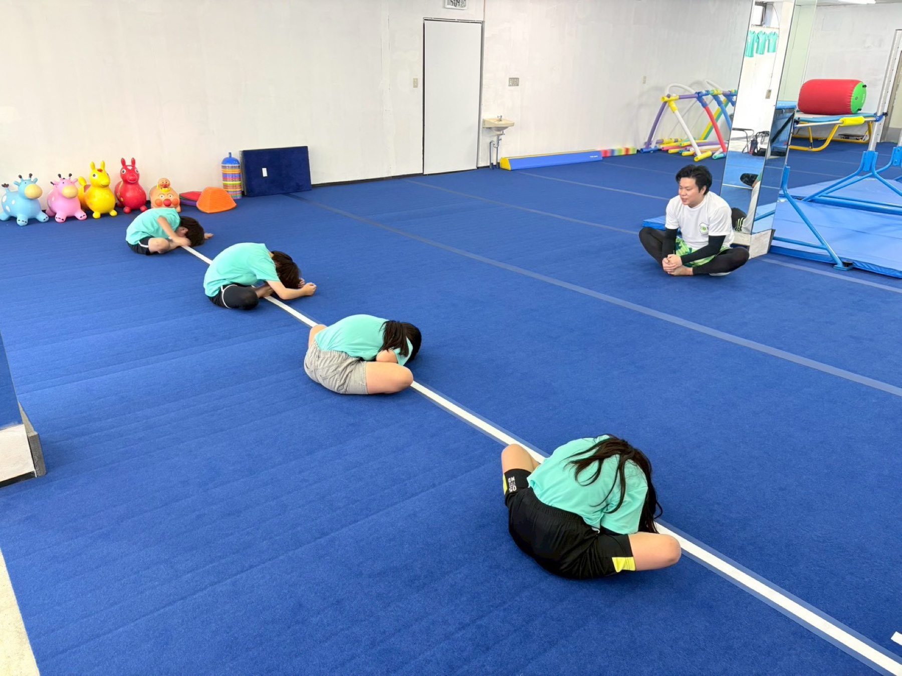 子どもたちが並んでストレッチをするレッスン風景
